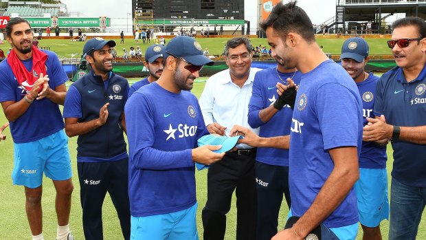 M.S. Dhoni presents Barinder Sran with his cap before the first one-day tie in Perth.