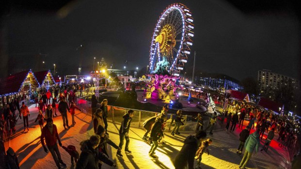 Hundreds gather around the Neptunbrunnen fountain at a Christmas market in Berlin. 