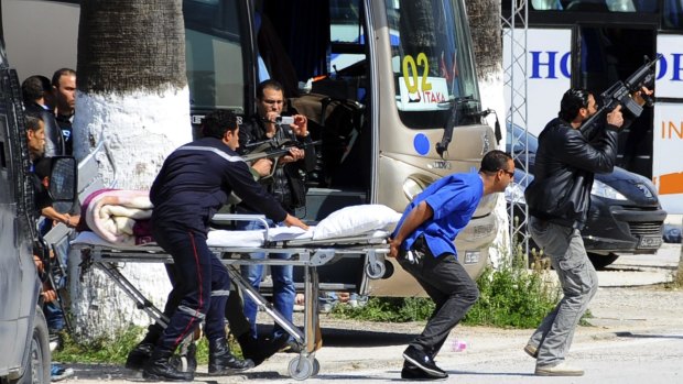 Rescue workers move an empty stretcher towards the museum.