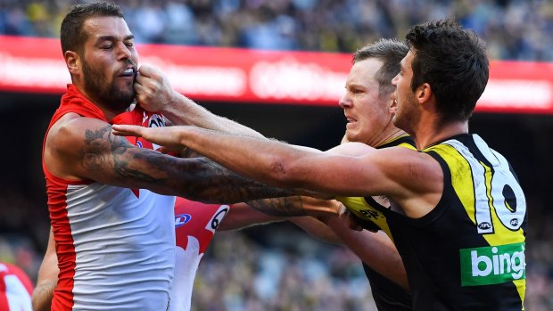 Lance Franklin of the Swans tussles with Alex Rance after Franklin's hit on Connor Menadue. 