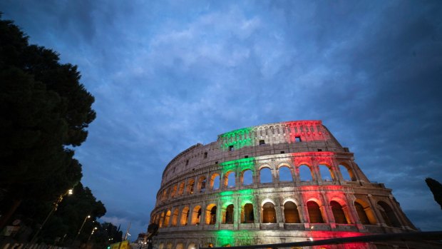 The colours of the Italian flag are projected onto the Colosseum.