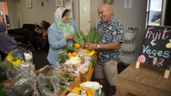 Mona Mahamed enjoys a laugh with delivery driver Eddy Younan as they sort donated surplus produce. 