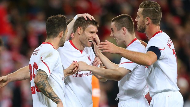 James Milner celebrates a goal with his Liverpool teammates.