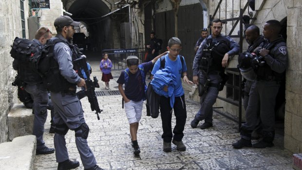 Israeli schoolchildren walk past security in Jerusalem's Old City on Thursday.