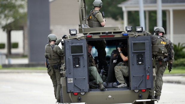 An FBI armoured vehicle patrols the perimeter of the crime scene where Baton Rouge police officers were shot.