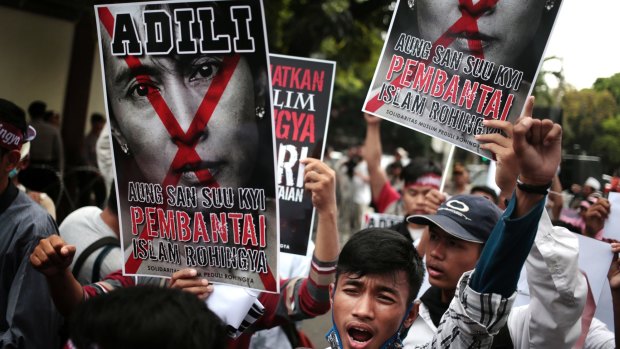 Protesters hold a defaced poster of  Aung San Suu Kyi during a rally demanding justice for Rohingyas outside Myanmar's embassy in Jakarta on Friday.