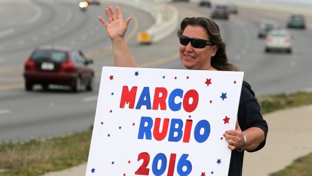 Linda Lewis, a supporter of Republican presidential candidate Marco Rubio, waves at passing traffic in Panama City Beach, Florida, on Tuesday. 