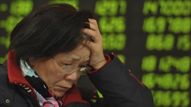 A woman reacts as she checks stock prices at a brokerage house in Fuyang in central China's Anhui province. 