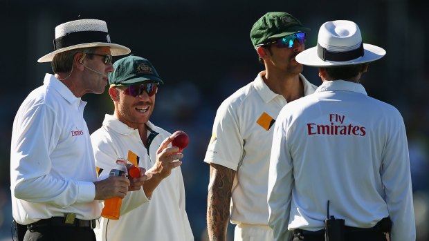 Not happy: David Warner speaks with he umpires over the condition of the ball.