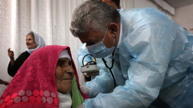 A doctor attends to an elderly Yazidi woman at a medical centre halfway between the northern Iraqi cities of Kirkuk and Erbil.