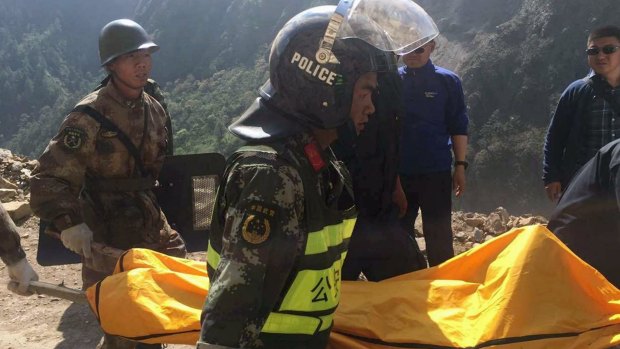 Rescuers carry the body of a woman in Gyirong county,Tibet. She was killed by falling rocks after a 7.3-magnitude earthquake hit the Tibet-Nepal border on Tuesday.