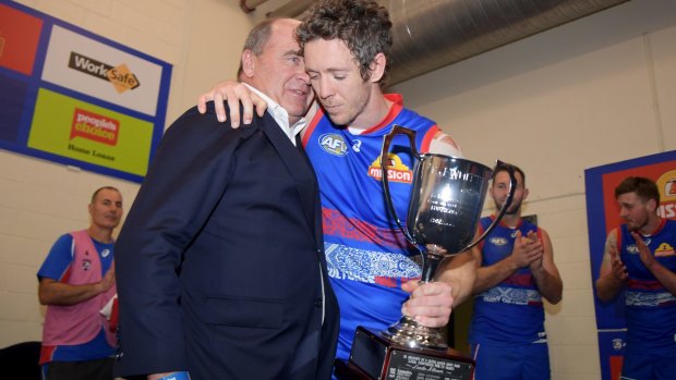 Silver service: Robert Murphy of the Western Bulldogs receives the EJ Whitten Cup from Ted Whitten Jr after the round 19 win over Essendon.