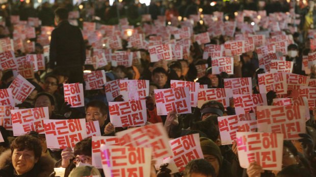 Protesters hold up placards during a rally calling for South Korean President Park Geun-hye to step down in Seoul.