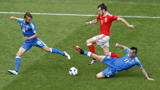 Always on the run: Wales forward Gareth Bale challenges for the ball with Slovakia's Dusan Svento and Marek Hamsik.