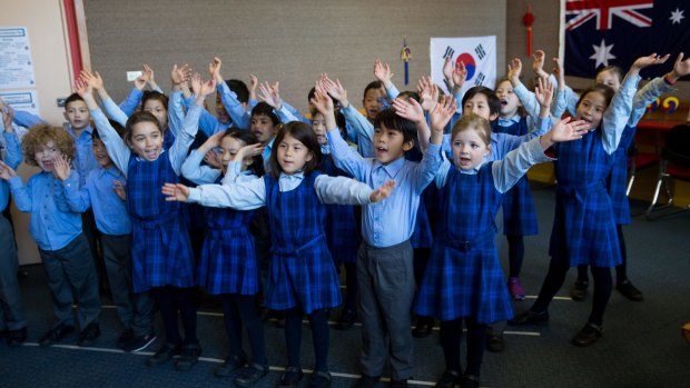 Students from Chatswood Public School's year one Korean bilingual class wave for the video link to their counterparts in Seoul. 