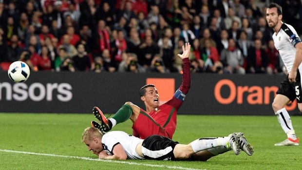Down he goes: Portugal's Cristiano Ronaldo gestures after being brought down in the box by Austria's Martin Hinteregger.