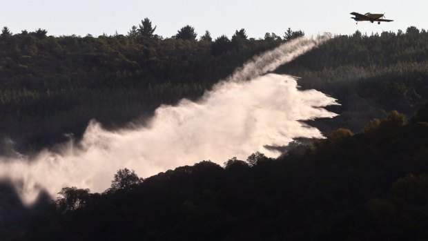 A plane drops fire retardant on a wildfire in Tambotinaja, Chile, on Thursday.