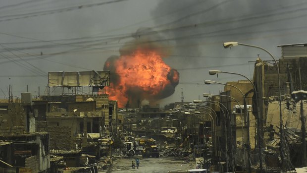 A fireball explodes in the air above the shattered streets of west Mosul on July 3.