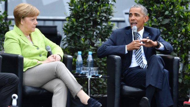 Barack Obama and Angela Merkel on stage at the Brandenburg Gate in Berlin, while Trump was in Brussels.