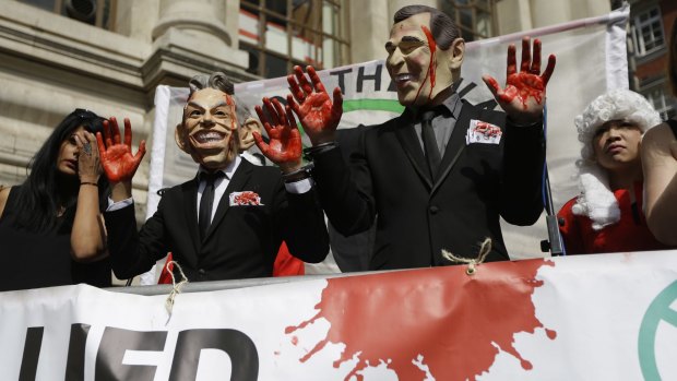 Bloddy hands: Protesters wearing Tony Blair and George W. Bush masks pose in London, shortly before the publication of the Chilcot report.