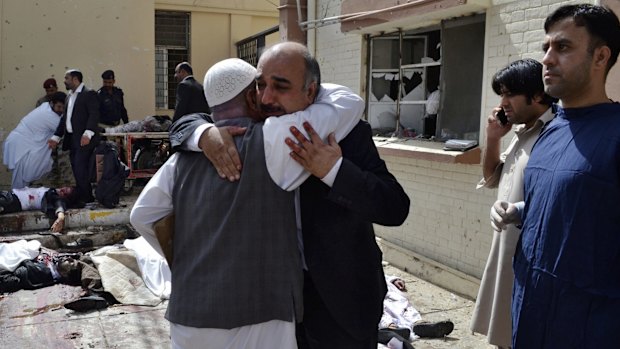 People comfort each other following a bomb blast in Quetta, Pakistan.