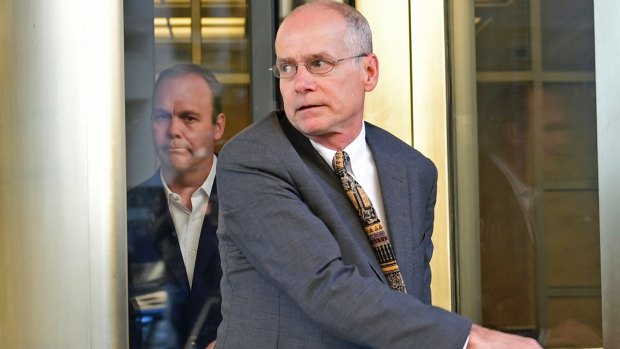 Rick Gates, left, walks through the revolving door as he leaves federal court in Washington on Monday.