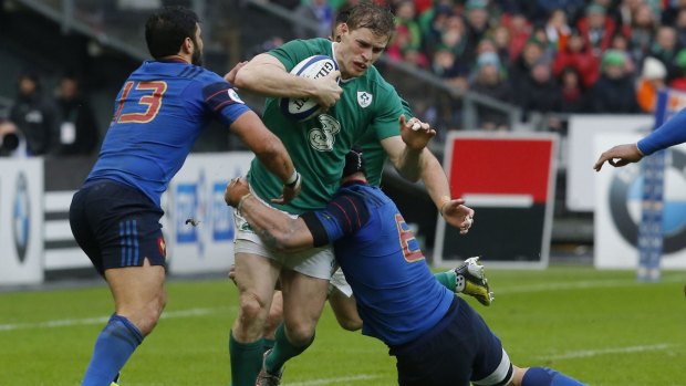 Ireland's Andrew Trimble, center is tackled by France's Maxime Mermoz, left, and Wenceslas Lauret.