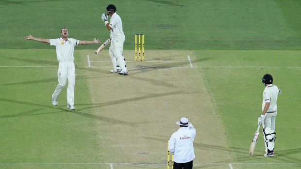 Out: Josh Hazlewood celebrates getting the wicket of Ross Taylor under lights.