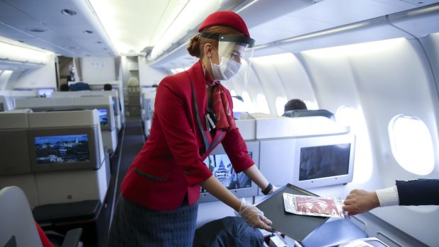 A flight attendant wears both a face mask and shield.