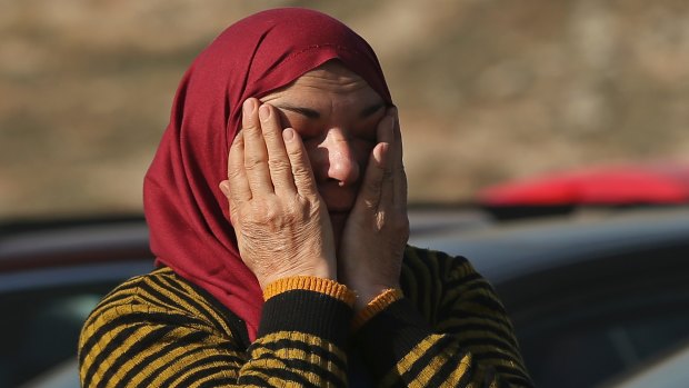 A Syrian woman evacuated from Aleppo waits to cross into Turkey.