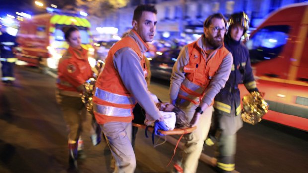 A woman is evacuated from the Bataclan theatre in Paris on Friday night.