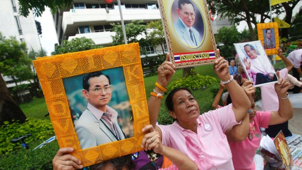 Thais hold portraits of King Bhumibol Adulyadej at Siriraj Hospital where the king is being treated in Bangkok.