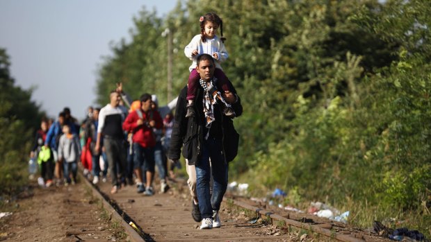 Last chance: Migrants cross Serbia's border with Hungary on Monday.