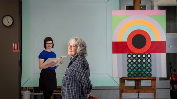 Artist Janet Dawson (front)  and NGV curator Beckett Rozentals, with John Peart's Corner square diagonal (rear) and James Doolin's Artificial landscape 67-6.