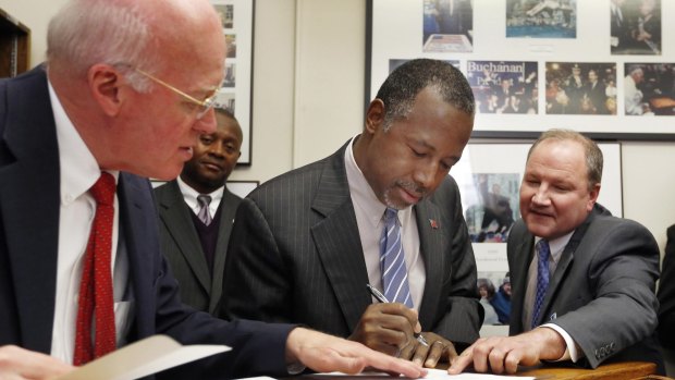 New Hampshire Secretary of State Bill Gardner (left) watches as Ben Carson gets help while filing papers to be on the nation's earliest presidential primary ballot on Friday.