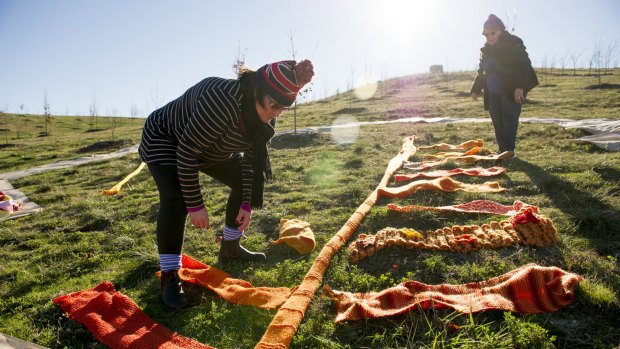 Tabitha Plovits and Jocelyn Plovits installing the world's largest knitted maple leaf ahead of the annual Warm Trees festival at The National Arboretum this July. 