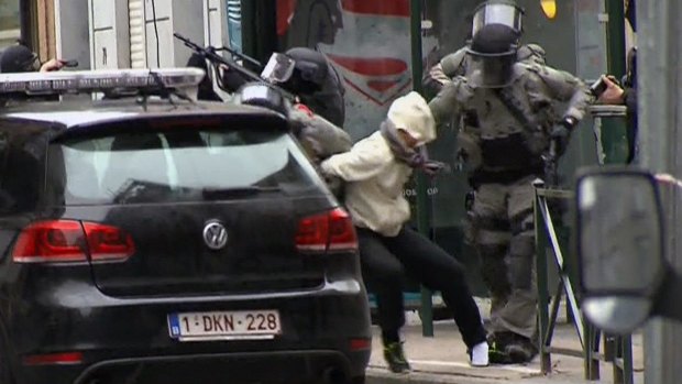 The moment Salah Abdeslam is bundled into a car by police.