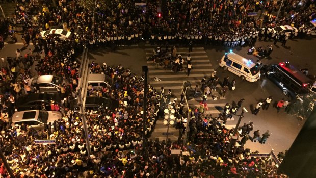 Police officers locked arms to close off an area for ambulances to get in.