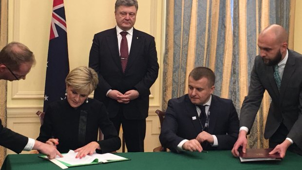 Foreign Minister Julie Bishop signed the agreement with Ukrainian Energy and Coal Industry Minister Volodymyr Demchyshyn (second from right) watched by Ukrainian President Petro Poroshenko (centre).