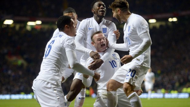 Centre of attention: Wayne Rooney is mobbed by teammates after scoring his first goal.