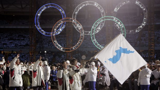 Korea flag-bearers carry a unification flag while leading their teams into the stadium during the 2006 Winter Olympics opening ceremony in Turin, Italy..