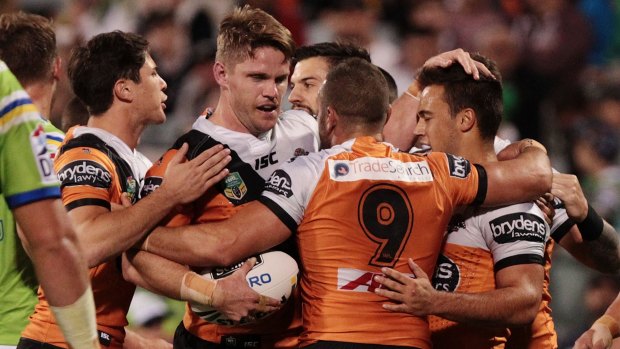 Rare bright spot: Chris Lawrence is congratulated by Tigers teammates after scoring a try during the match against Canberra.