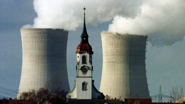 The church spire of the northern Bavarian village of Heidenfeld is dwarfed by the cooling towers of the Grafenrheinfeld nuclear power station. 
