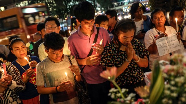 People pray for the victims of a bomb blast at the re-opened Erawan shrine in Bangkok.