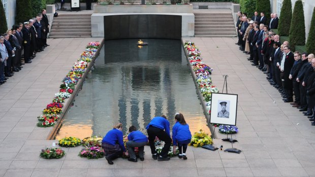 Wreaths are laid near the Pool of Reflection at the Australian War Memorial during a Last Post ceremony.

