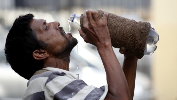 An Indian drinks water from a bottle in Allahabad, India.