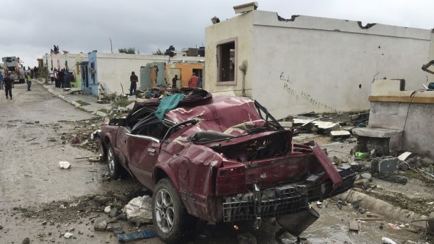 A damaged car sits on a road in Ciudad Acuna, northern Mexico, after a powerful tornado touched down. 