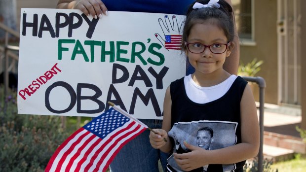 Delilah Roldan, 5, stands with her mother Yvonne Roland, holding a sign wishing President Barack Obama a happy father's day as he drives past en route to an interview with comedian Marc Maron in California.