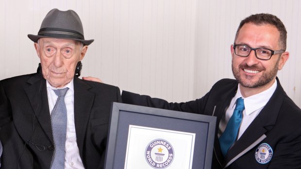 Marco Frigatti, from Guinness World Records, right, presents Israel Kristal a certificate for being the oldest living man.  The Auschwitz survivor is 112 years and 178 days old as of March 11. 