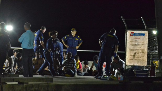 Customs officials and rescue personnel watch over survivors at Christmas Island after a boat capsized in July 2013.